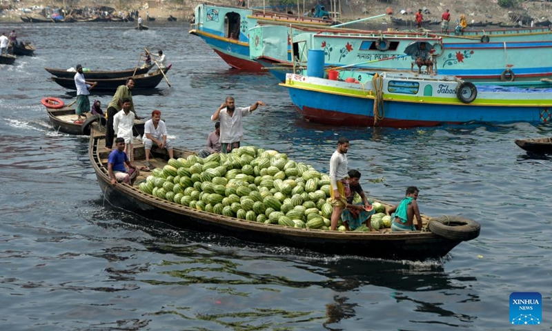 A boat loaded with watermelons sails on a river near a wholesale market in Dhaka, Bangladesh, March 21, 2023. Photo: Xinhua