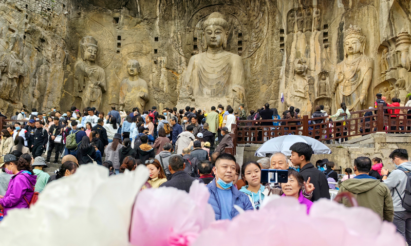 Tourists pose at the Yungang Grottoes in Datong, North China's Shanxi Province, on April 5, 2023, during the Qingming Festival. Photo: VCG