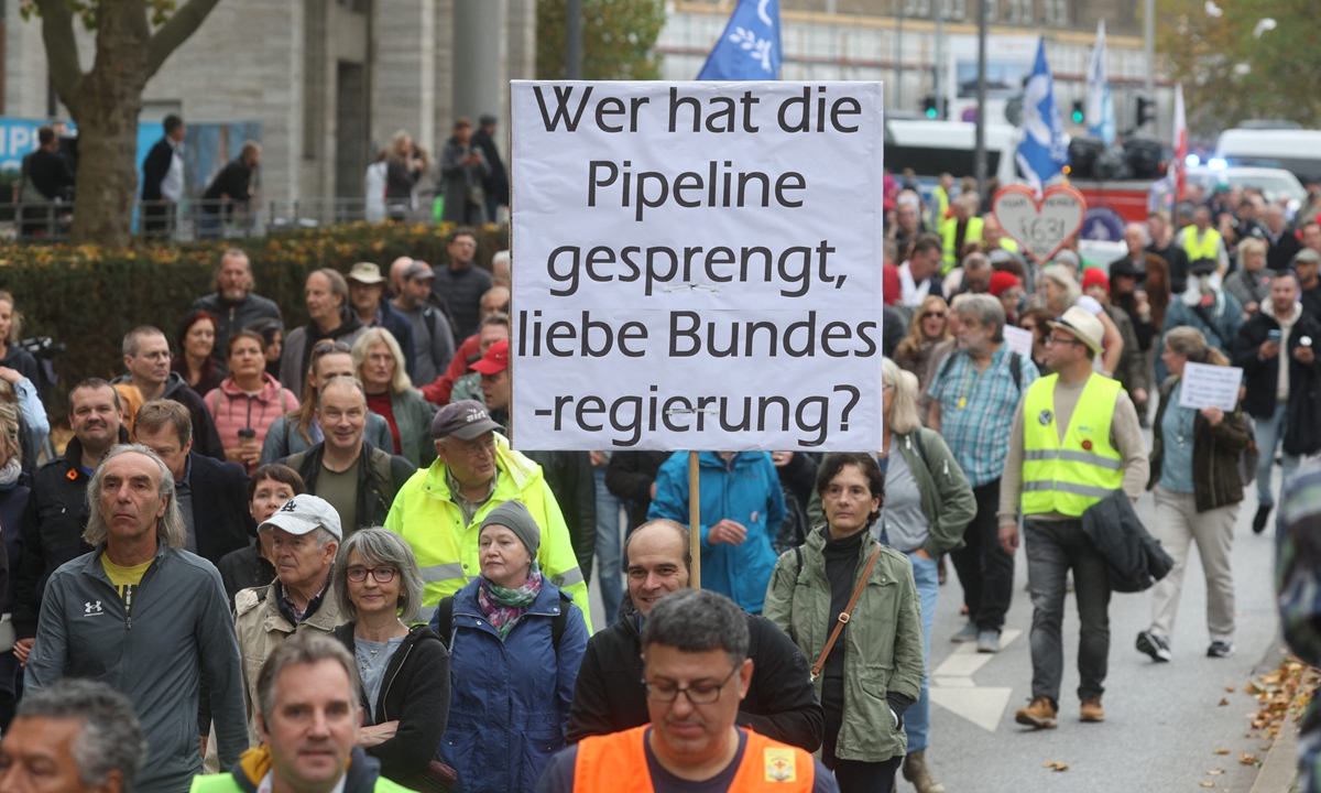 A man holds a sign reading 