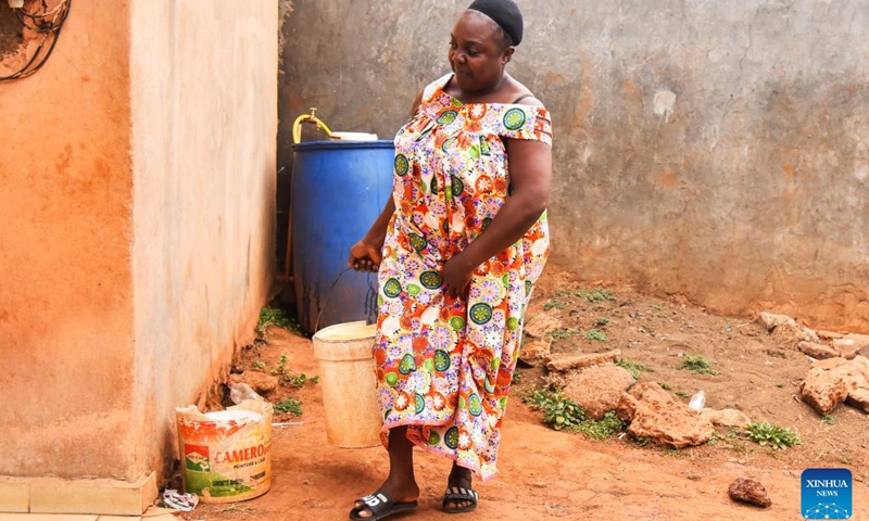Carine Nem leaves after drawing water from the tap in Bafoussam, Cameroon, March 2, 2023.(Photo: Xinhua)