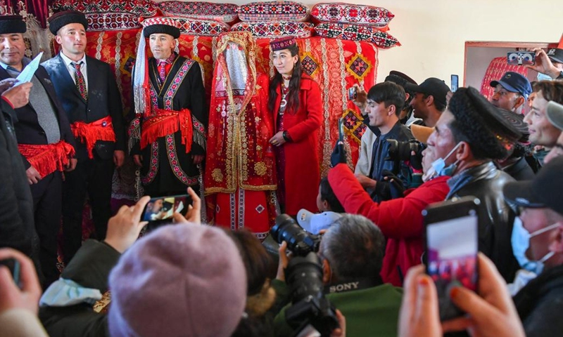 The new couple (3rd and 4th L) receive blessings at their wedding ceremony, while relatives and friends, villagers and tourists witness the happy moment in Taxkorgan Tajik Autonomous County, northwest China's Xinjiang Uygur Autonomous Region, March 19, 2023. In Taxkorgan Tajik Autonomous County, many young men and women prefer to get married in the spring season.(Photo: Xinhua)