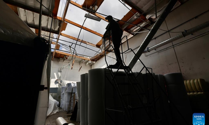 A person checks a warehouse rooftop damaged by a tornado in the city of Montebello, Los Angeles, the United States, on March 23, 2023. Los Angeles area was hit by a rare tornado on Wednesday, the strongest one to impact LA Metro area since March 1983, according to the U.S. National Weather Service (NWS).(Photo: Xinhua)