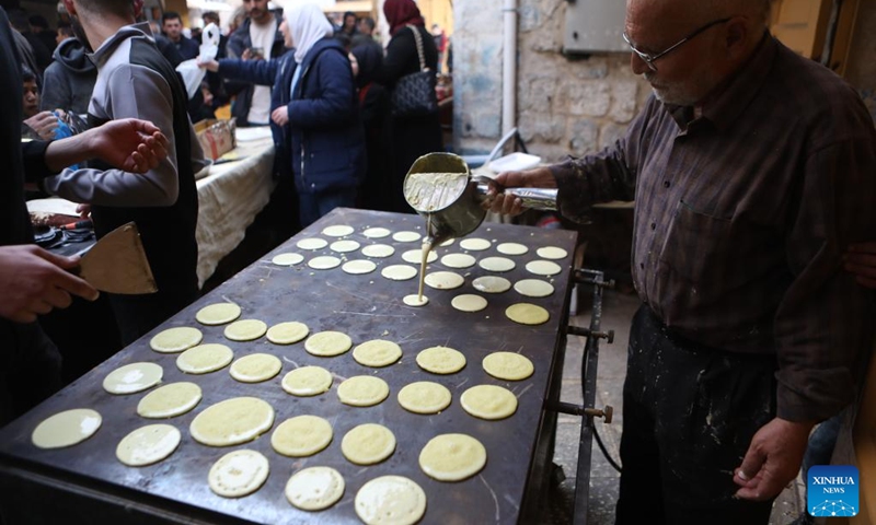A Palestinian man makes traditional sweets on the first day of the holy month of Ramadan at a market in the West Bank city of Hebron, on March 23, 2023.(Photo: Xinhua)