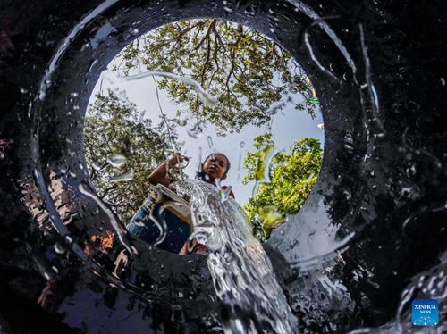 A resident pours water into a bucket at a residential area on the occasion of World Water Day in Quezon City, the Philippines, March 22, 2023.(Photo: Xinhua)