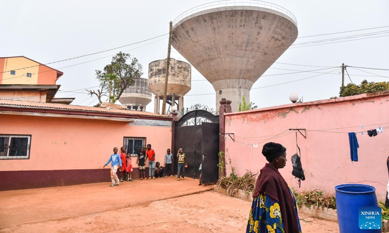 This photo taken on March 2, 2023 shows a grandmother and children in a yard next to the water tower in Bafoussam, Cameroon.(Photo: Xinhua)