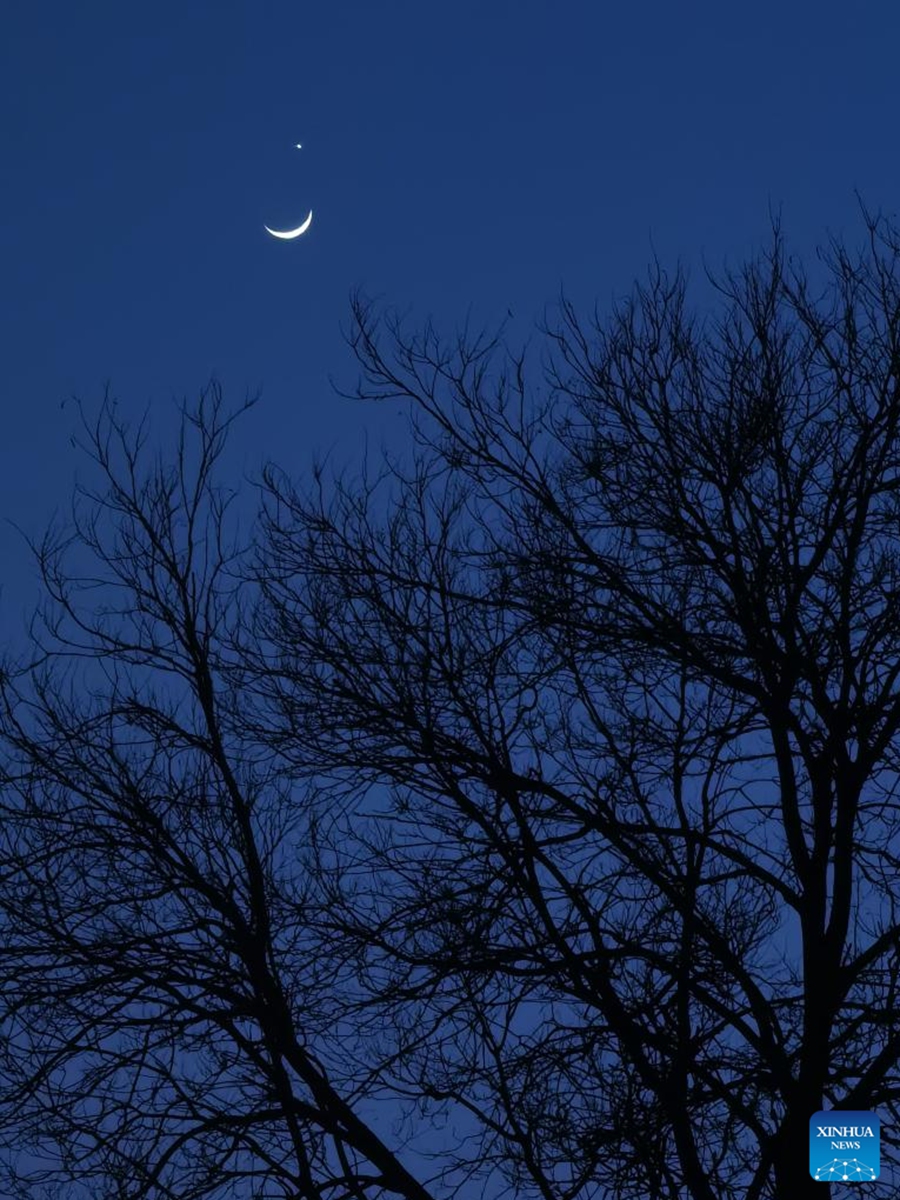 This photo taken with a mobile phone shows the planet Venus and the crescent moon in Beijing, capital of China, March 24, 2023. (Xinhua/Luo Xiaoguang)