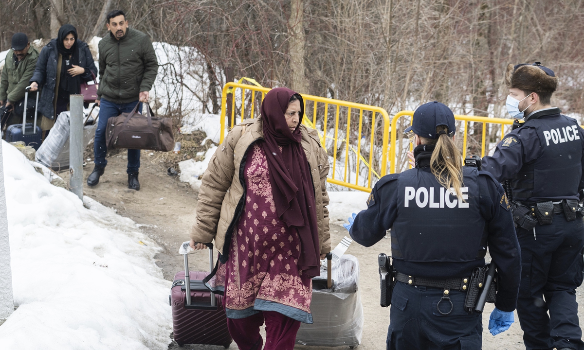 Royal Canadian Mounted Police officers stop people as they enter Canada via Roxham road on the Canada-US border in Hemmingford, Quebec, March 25, 2023. US President Joe Biden on Friday announced that he and his Canadian Prime Minister Justin Trudeau reached a deal on curbing illegal immigration. The plan has been criticized by migrant rights activists who claim it will only push people to more dangerous crossings. Photo: VCG