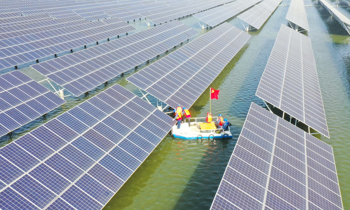 Engineers from a local power company steer a work boat among rows of solar panels inside a solar power plant built on a fish farm on March 29, 2023 in East China's Anhui Province. The province recorded a 15.3 percent annual increase in solar power generation in 2022, data from the local statistics bureau showed. Photo: VCG
