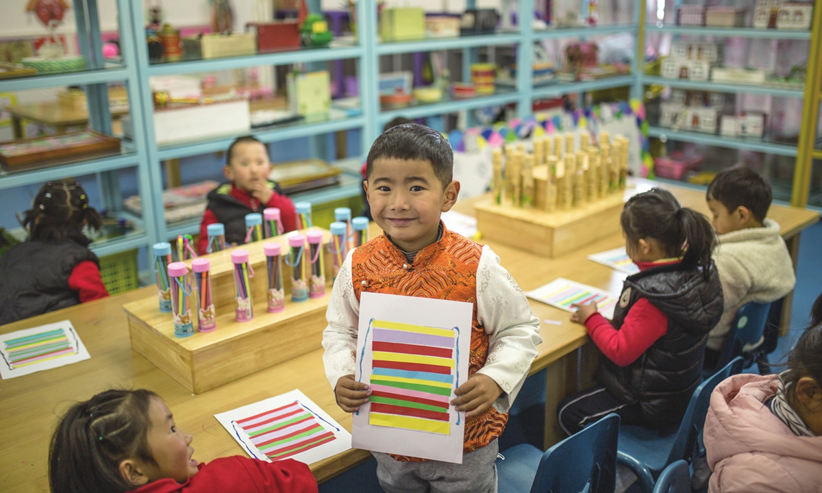 A boy shows the bangdian, or Tibetan apron, he just colored at a workshop in Lhasa Experiment Kindergarten on March 22, 2023.
 Photo: Shan Jie/GT

