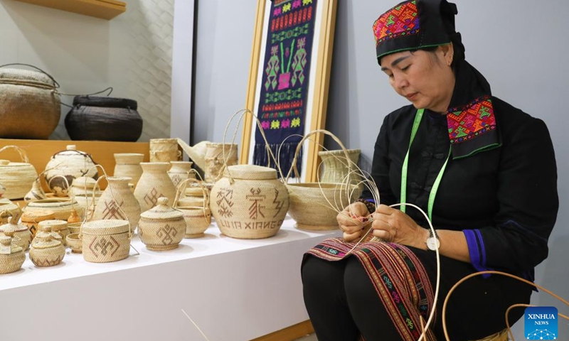 An inheritor of Li rattan weaving makes handicrafts during the Innovation and Development of Sanya Exhibition in Boao, south China's Hainan Province, March 28, 2023. The exhibition is held here from March 28 to March 31(Photo: Xinhua)