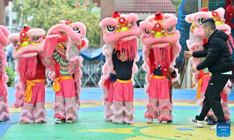 Children prepare to practice lion dance at a kindergarten in Tengxian County of Wuzhou, south China's Guangxi Zhuang Autonomous Region, March 28, 2023. The Tengxian Lion Dance, which is listed as a national intangible cultural heritage, is a combination of martial arts, dancing, music and acrobatics. In recent years, Tengxian County has been actively integrating the lion dance with courses in kindergartens and schools, with the goal of passing on this traditional art form to younger generations.(Photo: Xinhua)
