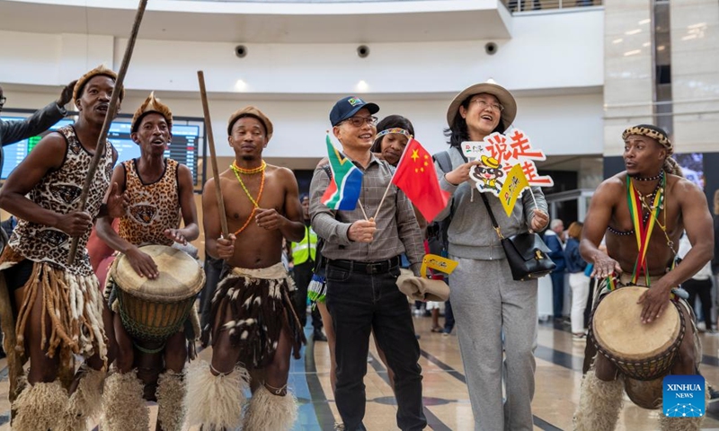 Dancers interact with tourists from China during a welcoming ceremony at the OR Tambo International Airport in Johannesburg, South Africa, on March 29, 2023. South Africa's tourism authority on Wednesday welcomed the first group of tourists from China since the outbreak of COVID-19.(Photo: Xinhua)