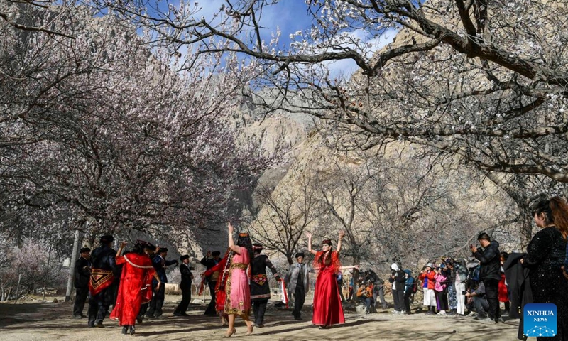 Tourists watch a traditional wedding ceremony in Bahrigzi Village of Tar Tajik Township, Akto County, northwest China's Xinjiang Uygur Autonomous Region, March 28, 2023. Tar Tajik Township, nestled in the hinterland of the Kunlun Mountains, is a key national rural tourism village under Akto County, northwest China's Xinjiang Uygur Autonomous Region. As the weather gets warmer, apricot flowers are in full bloom here. The magnificent natural scenery and unique folk customs attract many tourists.(Photo: Xinhua)