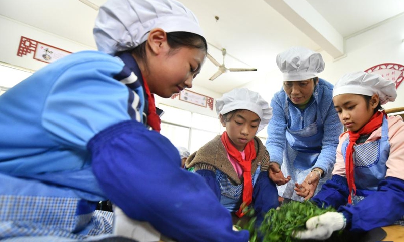 Pupils learn to make tea at a primary school in Cangwu County of Wuzhou City, south China's Guangxi Zhuang Autonomous Region, March 29, 2023. In recent years, Wuzhou City has introduced lion dance, Cantonese opera and tea art into the campus to enrich students' extracurricular life.(Photo: Xinhua)
