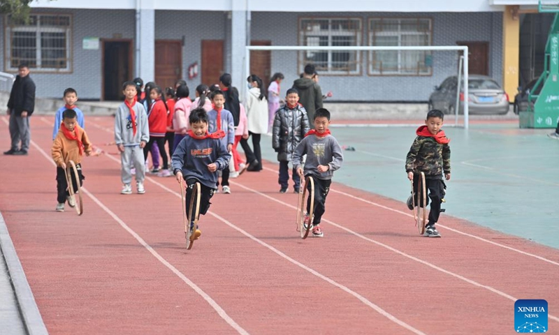 Students roll bamboo rings during a PE class at Xiayi Ethnic School in Mengshan County of Wuzhou City, south China's Guangxi Zhuang Autonomous Region, Feb. 22, 2023. In recent years, Wuzhou City has introduced lion dance, Cantonese opera and tea art into the campus to enrich students' extracurricular life.(Photo: Xinhua)