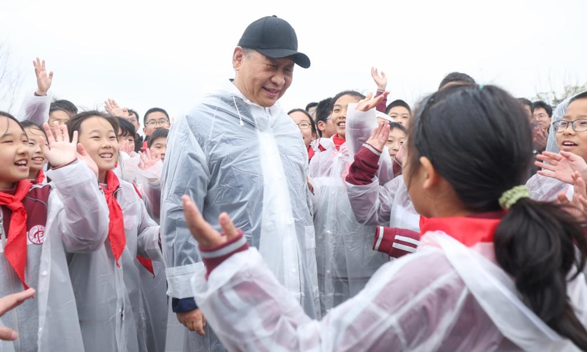 Chinese President Xi Jinping, also general secretary of the Communist Party of China Central Committee and chairman of the Central Military Commission, talks with young students during a voluntary tree planting activity in Beijing, capital of China, April 4, 2023. Xi and other leaders, including Li Qiang, Zhao Leji, Wang Huning, Cai Qi, Ding Xuexiang, Li Xi, and Han Zheng, planted trees with local people at a city park in the eastern district of Chaoyang in the spring shower. (Xinhua)