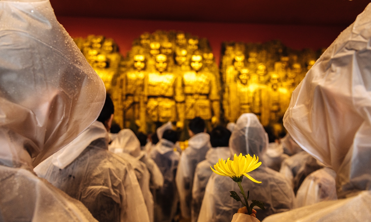 People stand in silence and pay tribute to martyrs with flowers at the Museum of the War of People's Resistance Against Japanese Aggression in Beijing on April 4, 2023, at an event to honor the country's martyrs on Qingming Festival. Photo: Li Hao/GT