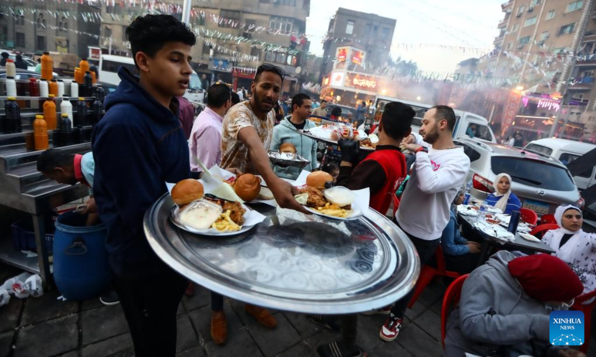 A man serves iftar meals to people during Ramadan in Cairo, Egypt, on April 7, 2023. Photo:Xinhua