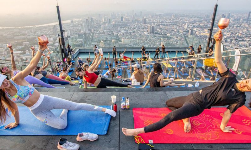 Yoga enthusiasts practice yoga at an observation deck on the rooftop of the King Power Mahanakhon building in Bangkok, Thailand, April 8, 2023. (Xinhua/Wang Teng)
