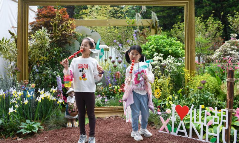 Children pose for photos at the Greater Bay Area Flower Show in Shenzhen, south China's Guangdong Province, April 8, 2023. The 10-day flower show was opened at Shenzhen Fairy Lake Botanical Garden on Saturday, attracting 80 exhibitors from 13 countries and regions including Australia, Britain, France, Japan, South Korea and the United States. (Xinhua/Liang Xu)