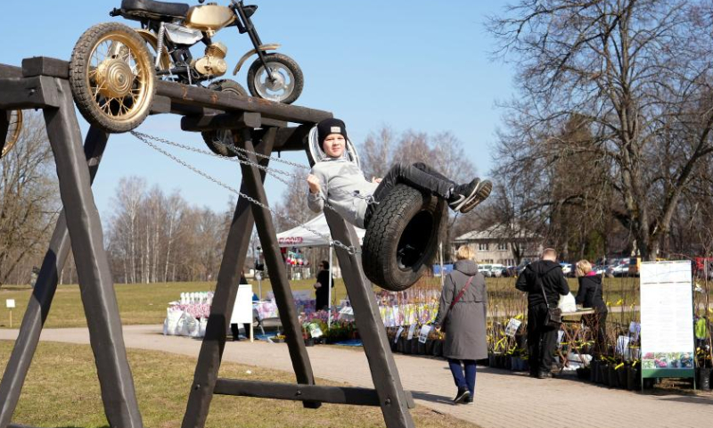 A child plays during the Swing festival in Sigulda, Latvia, April 8, 2023. Many specially designed swings have been erected for the Swing festival in Sigulda. (Photo by Edijs Palens/Xinhua)
