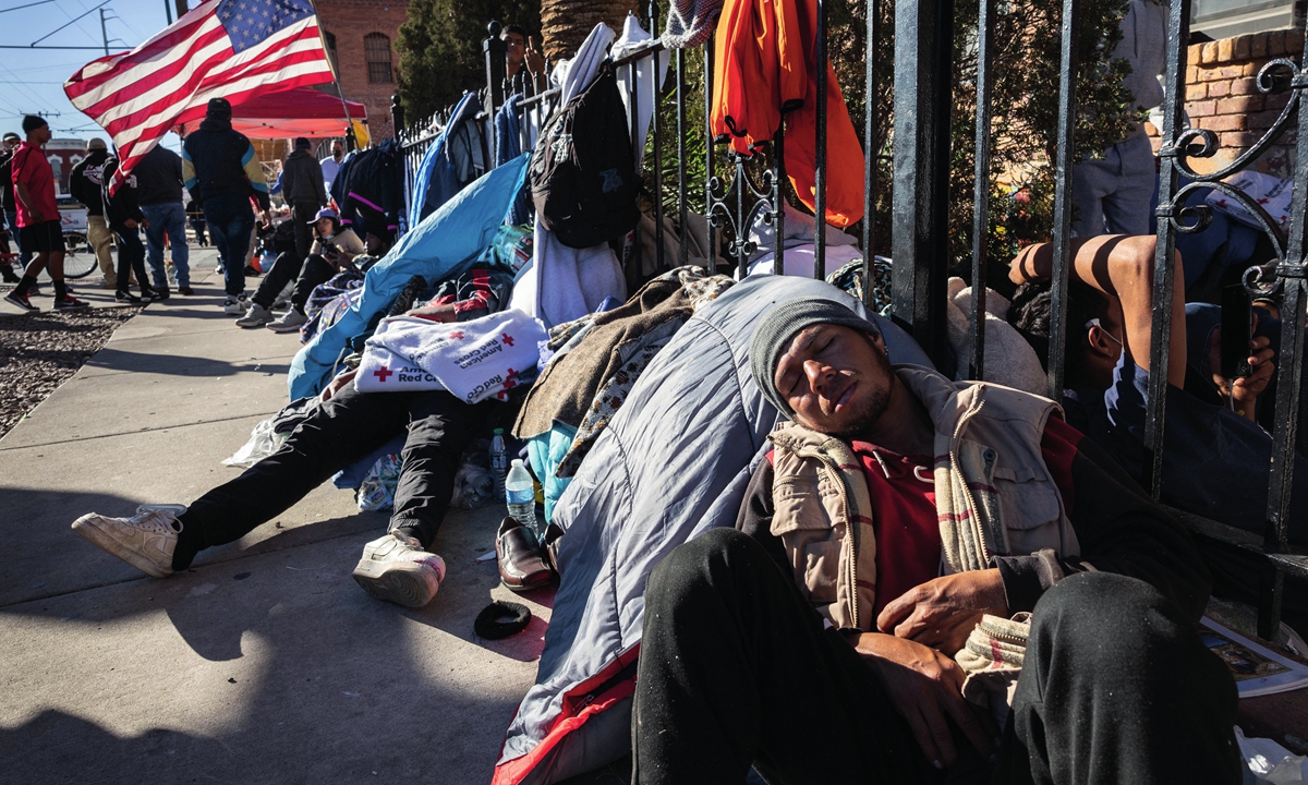 Immigrants sleep on a sidewalk near a migrant shelter on January 6, 2023, in El Paso, the US. Photo: AFP
