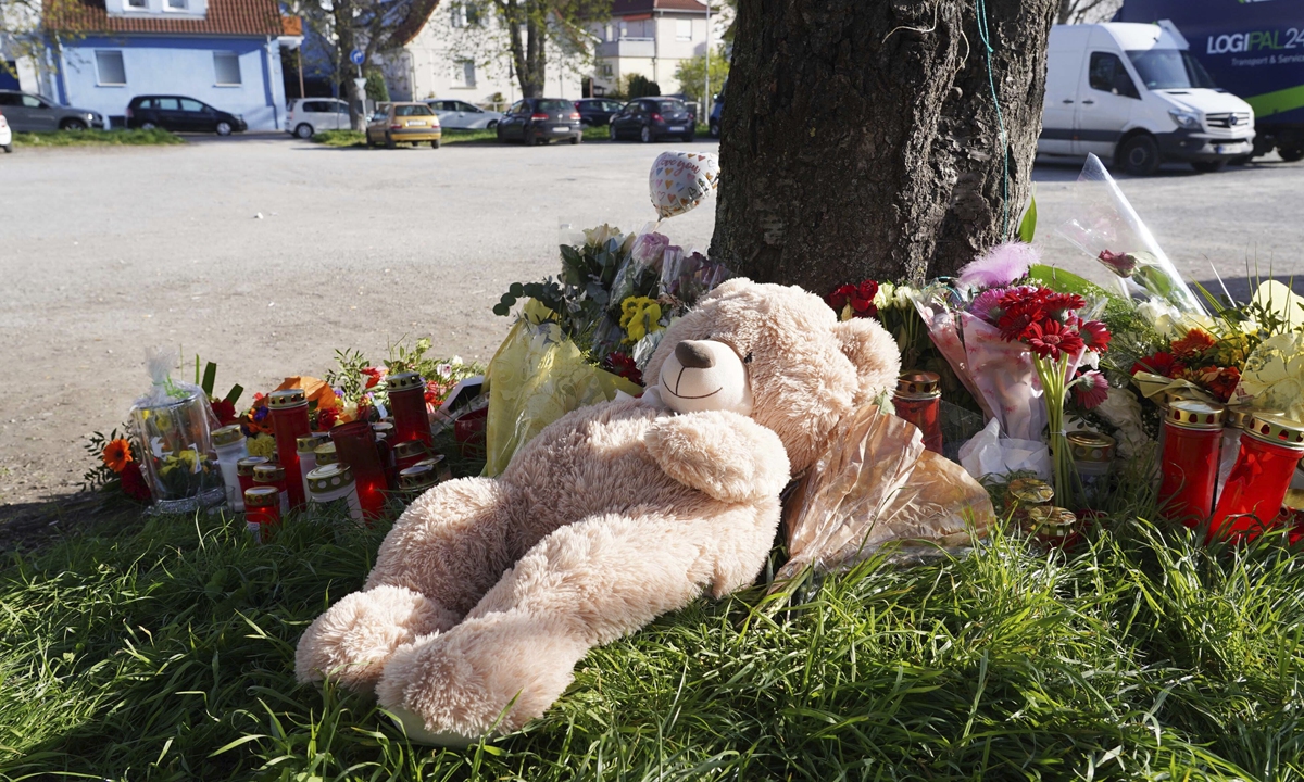 A stuffed bear, flowers and candles are placed near a crime scene in Asperg, some 20 kilometers west of Stuttgart in southern Germany on April 10, 2023. On Saturday night, an 18-year-old was shot and killed at the scene and a peer was seriously injured in a deadly shooting. A suspect has been arrested. Photo: VCG