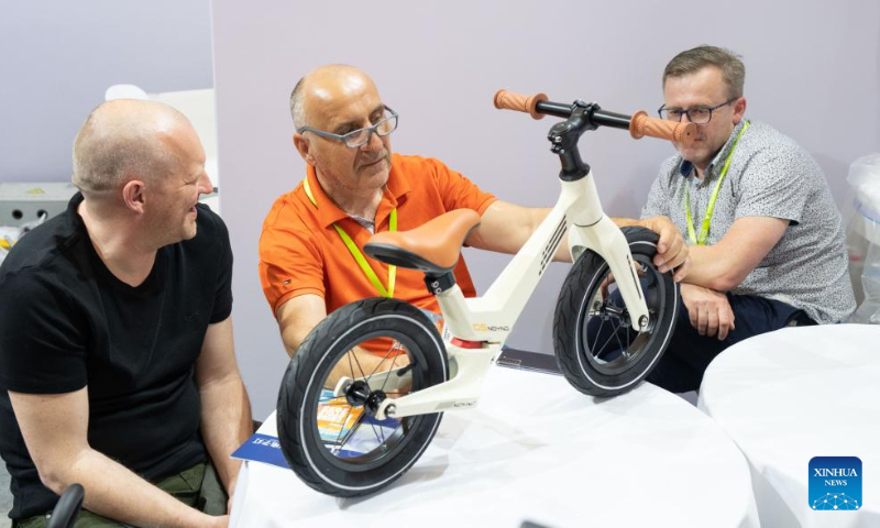 Polish traders look at a kids bike during the 31st China International Bicycle Fair in east China's Shanghai, May 5, 2023. (Xinhua/Cai Yang)