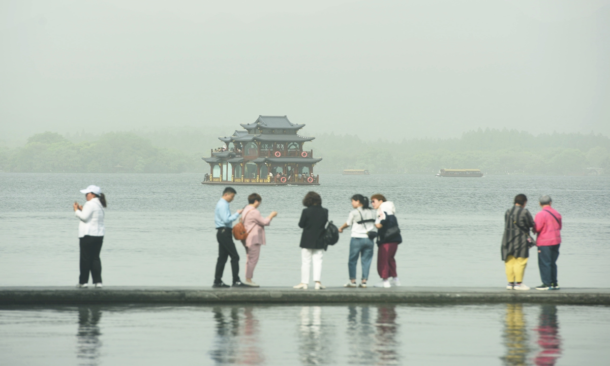 Tourists visit the West Lake scenic area in Hangzhou, capital of East China's Zhejiang Province on April 12, 2023. The city experienced sand and dust storm on April 12, according to the authorities. Photo: VCG
