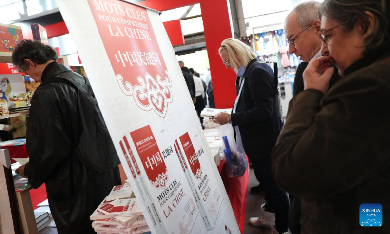 Visitors look at books displayed during an exhibition on the Chinese culture at the Porte de Versailles exhibition center in Paris, France, May 2, 2023. (Xinhua/Gao Jing)