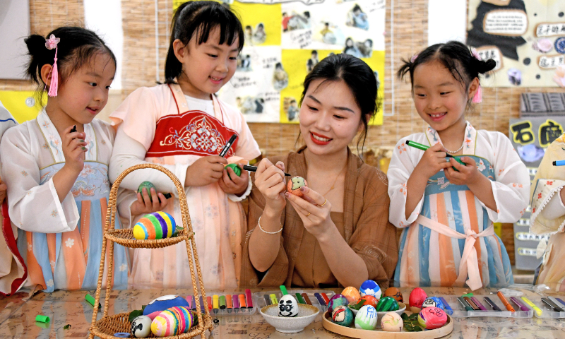 Children at a kindergarten paint eggshells under a teacher's guidance in Xianju county, East China's Zhejiang Province, on May 5, 2023. The activity aims to help children learn about the start of summer, the 7th solar term of the year, which begins on May 6 in 2023. Start of summer signals the transition of seasons. The traditional Chinese solar calendar divides the year into 24 solar terms. Photo: VCG
