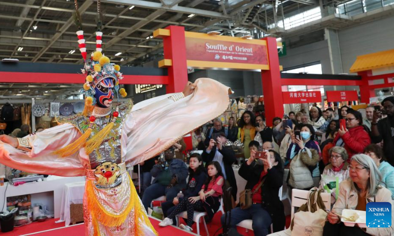 An artist performs mask-shifting tricks of Chuanju (Sichuan opera) during an exhibition on the Chinese culture at the Porte de Versailles exhibition center in Paris, France, May 2, 2023. (Xinhua/Gao Jing)