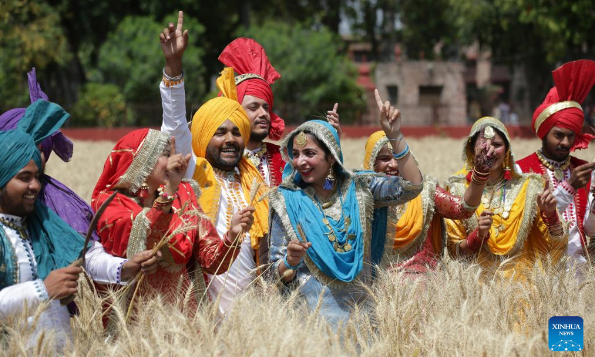 People wearing traditional Punjabi attire sing folk songs and perform folk dances during festival Baisakhi in a wheat farm in Amritsar district of India's northern Punjab state, April 13, 2023. Baisakhi is one of the most popular festivals celebrated in the Indian state of Punjab to mark the harvest. Photo:Xinhua