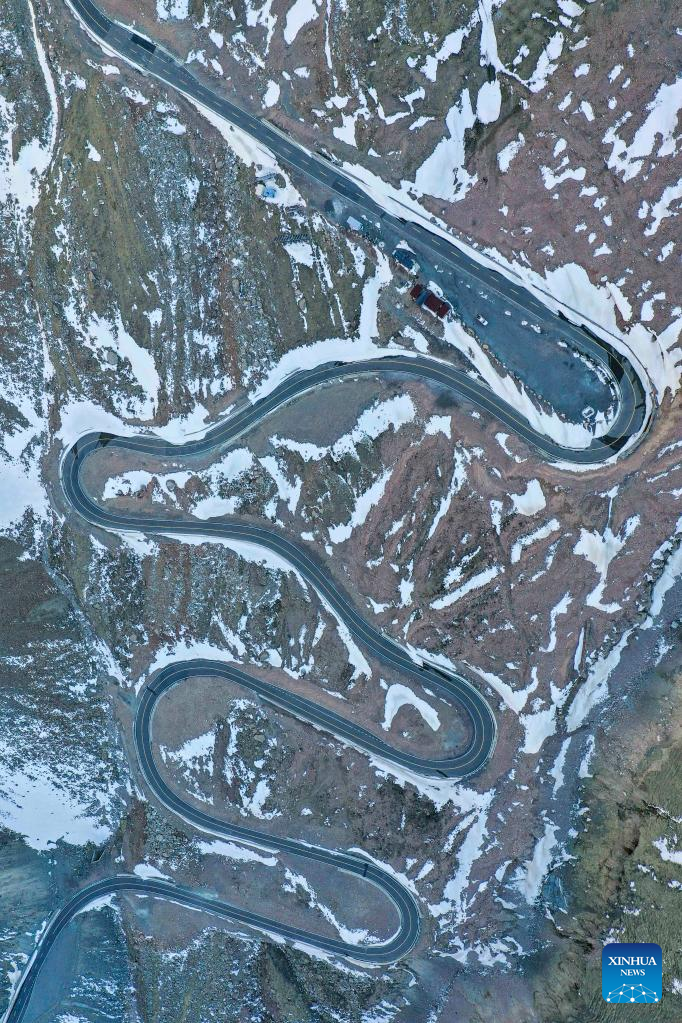 This aerial photo taken on May 10, 2023 shows a winding mountain road just cleared of snow on the Dushanzi-Kuqa Highway in northwest China's Xinjiang Uygur Autonomous Region. (Xinhua/Hu Huhu)