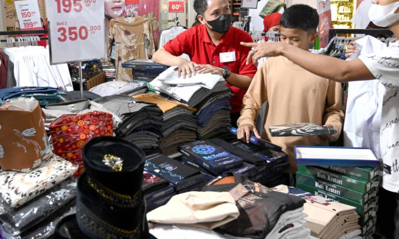 People shop during the midnight sale ahead of Eid al-Fitr in Tangerang, Banten Province, Indonesia, April 15, 2023. Midnight sales are popular in Indonesia, offering discounts ahead of holidays. (Xinhua/Agung Kuncahya B.)
