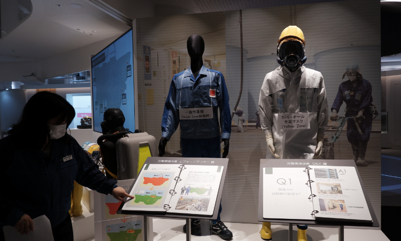 A staff member introduces the radioactivity protective suits at the TEPCO Decommissioning Archive Center in Japan on May 10, 2023. Photo: Xu Keyue/GT
