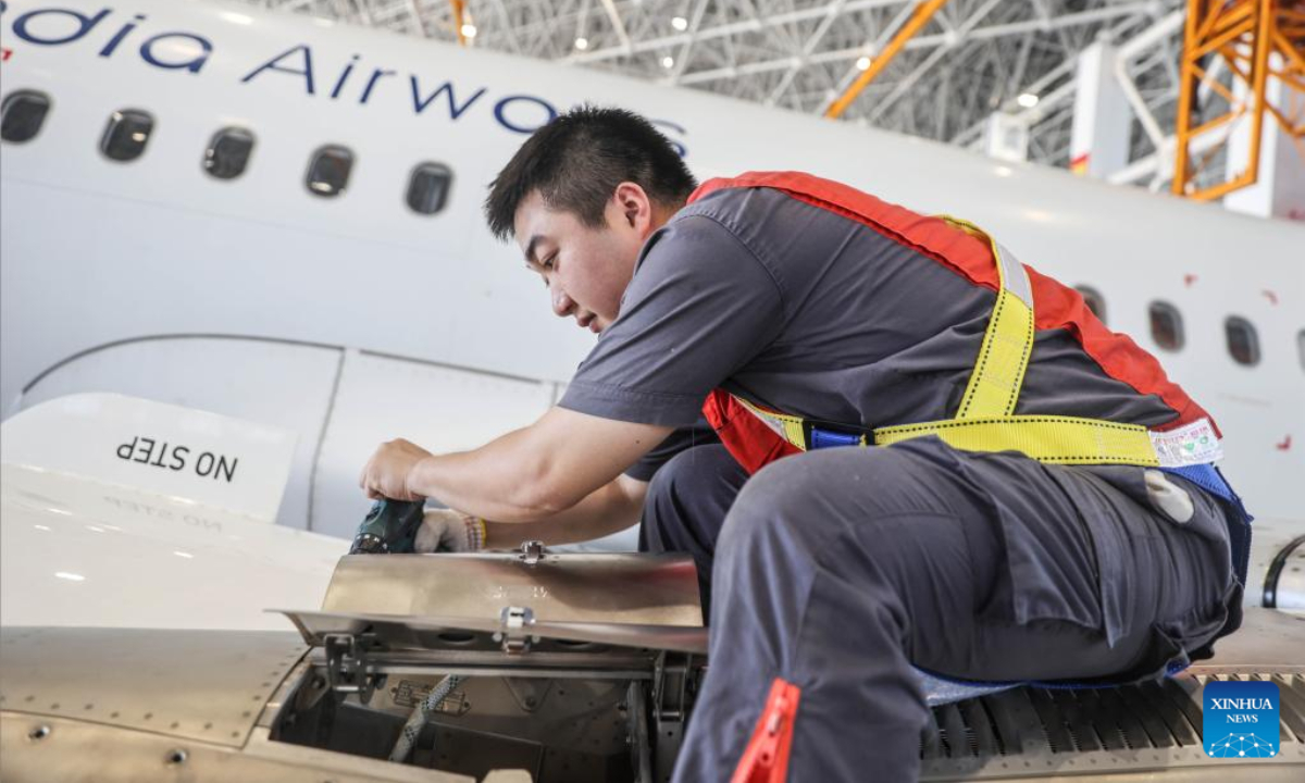 A worker of Grand China Aviation Maintenance Co., Ltd. (GCAM) maintains an airplane in Haikou, capital of south China's Hainan Province, May 5, 2023. An Airbus A320 airplane of Cambodia Airways was parked at a hangar of Hainan Free Trade Port's aircraft maintenance base to receive examination and maintenance services provided by GCAM on Friday. Photo:Xinhua