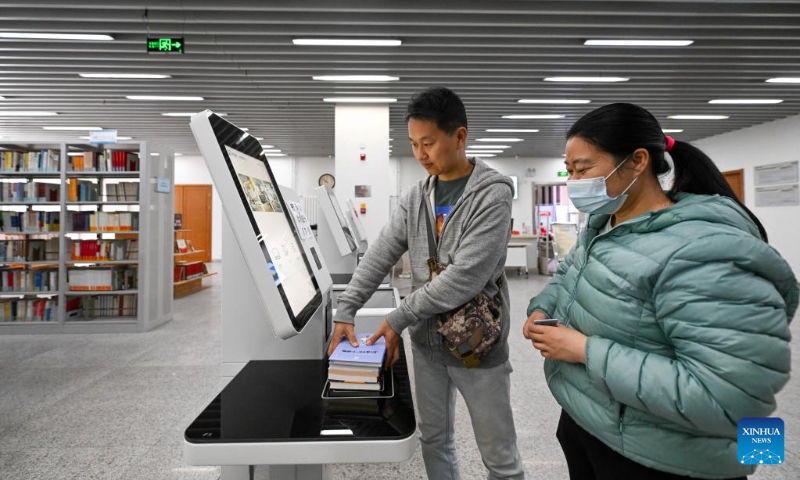 A woman returns books at a library in the culture center of Hexi District, north China's Tianjin, April 21, 2023. Hexi District in north China's Tianjin Municipality has offered convenient reading service to its readers by developing a reading service system. With the system, libraries in the district can share their resources and readers can borrow and return books by one stop. (Xinhua/Sun Fanyue)