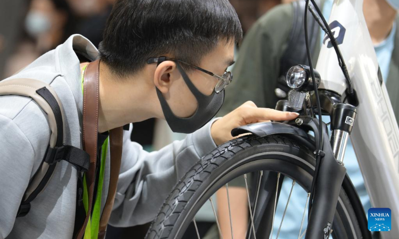 A visitor looks at a bicycle during the 31st China International Bicycle Fair in east China's Shanghai, May 5, 2023. (Xinhua/Li He)
