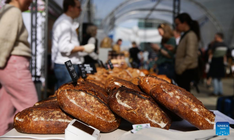 Vendors and buyers talk at a bread festival in Brussels, Belgium, May 6, 2023. A bread festival was held in Brussels on Saturday to let people taste and buy various kinds of bread product from European countries. (Xinhua/Zheng Huansong)
