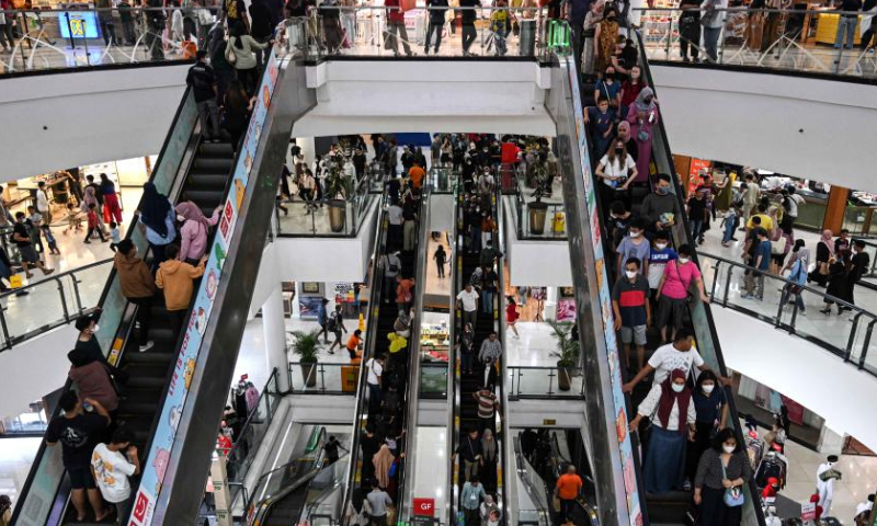 People shop during the midnight sale ahead of Eid al-Fitr in Tangerang, Banten Province, Indonesia, April 15, 2023. Midnight sales are popular in Indonesia, offering discounts ahead of holidays. (Xinhua/Agung Kuncahya B.)