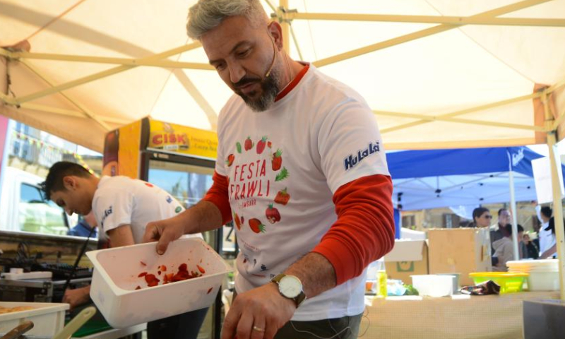 A man makes food with fresh strawberries in Mgarr, Malta, on April 16, 2023. Malta on Sunday held its annual strawberry festival in Mgarr, a picturesque agricultural village in north Malta. (Photo by Jonathan Borg/Xinhua)