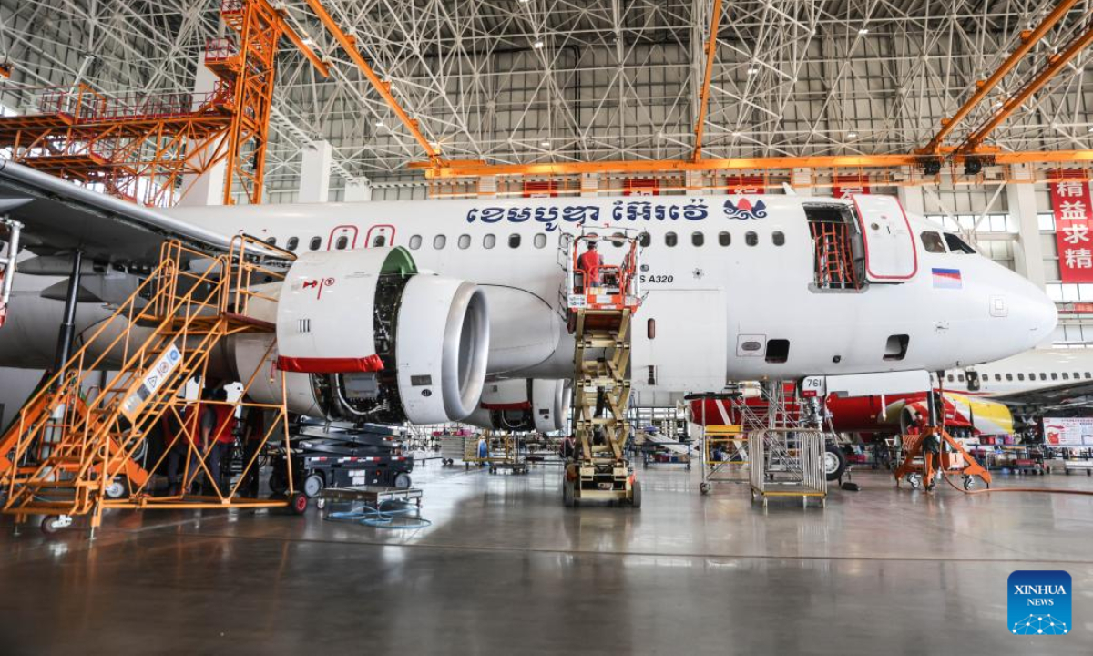 Workers of Grand China Aviation Maintenance Co., Ltd. (GCAM) maintain an airplane in Haikou, capital of south China's Hainan Province, May 5, 2023. An Airbus A320 airplane of Cambodia Airways was parked at a hangar of Hainan Free Trade Port's aircraft maintenance base to receive examination and maintenance services provided by GCAM on Friday. Photo:Xinhua
