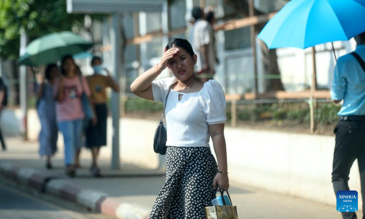 A woman shields herself from the sun on a hot day in Yangon, Myanmar, April 27, 2023. Photo:Xinhua