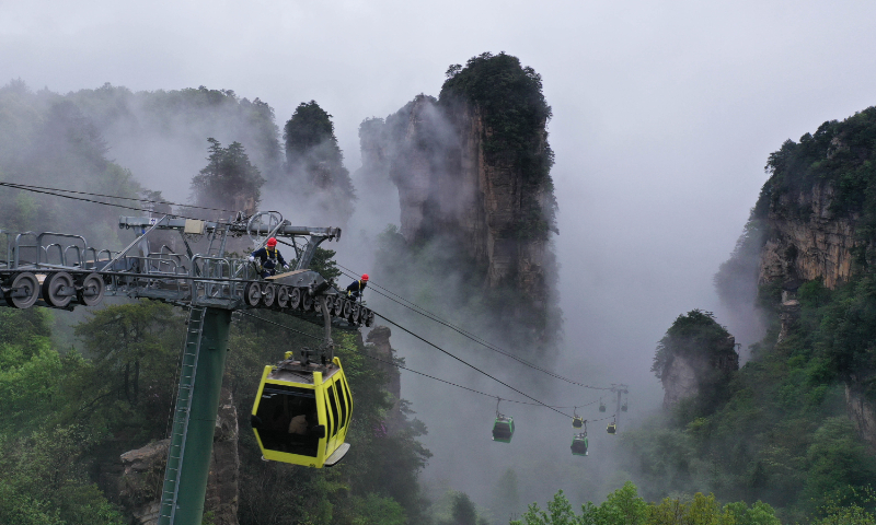 Repairmen check the equipment and bearings on a ropeway at Zhangjiajie National Forest Park in Zhangjiajie, Central China's Hunan Province, on April 24, 2023. As the May Day holidays approach, the park is striving to eliminate safety risks for an expected tourist peak. Photo: VCG