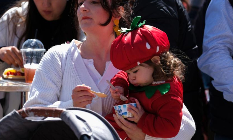 A little girl eats food made with strawberries in Mgarr, Malta, on April 16, 2023. Malta on Sunday held its annual strawberry festival in Mgarr, a picturesque agricultural village in north Malta. (Photo by Jonathan Borg/Xinhua)