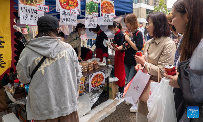 People queue up to buy snacks during a Sichuan food festival held at Nakano Central Park, Tokyo, Japan, on May 14, 2023. The Sichuan food festival was held here from May 13 to May 14. (Xinhua/Zhang Xiaoyu)