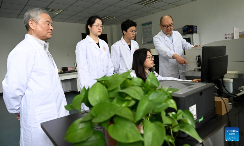 Researcher Han Fusheng (1st L) and associate researcher Wang Xingfu (1st R) from a special aerospace metal materials research team of Institute of Solid State Physics of Chinese Academy of Science (CAS) instruct students to use direct-reading spectrometer at Hefei Institutes of Physical Science of CAS in Hefei, capital of east China's Anhui Province, on April 19, 2023. (Xinhua/Huang Bohan)