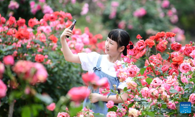 A girl enjoys flowers at a flower base in Dongmen Village, Jiuzhou Township, Huangping County of Qiandongnan Miao and Dong Autonomous Prefecture, southwest China's Guizhou Province, May 13, 2023. With flowers blooming in the early summer, the flower industry in China witnesses robust growth. (Photo by Wang Chao/Xinhua)