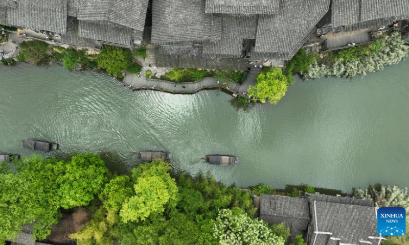 This aerial photo taken on May 2, 2023 shows tourists visiting an ancient village on boats in Zunyi City, southwest China's Guizhou Province. China is witnessing a travel boom during this year's five-day May Day holiday. (Photo by Yuan Fuhong/Xinhua)